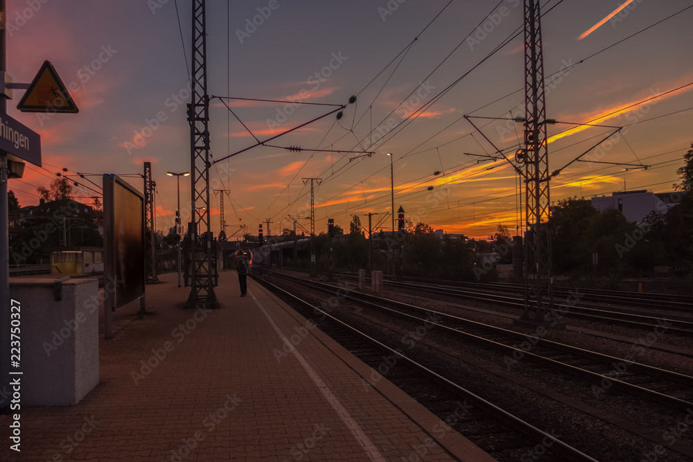 A colorful sunrise above the train station of a German city