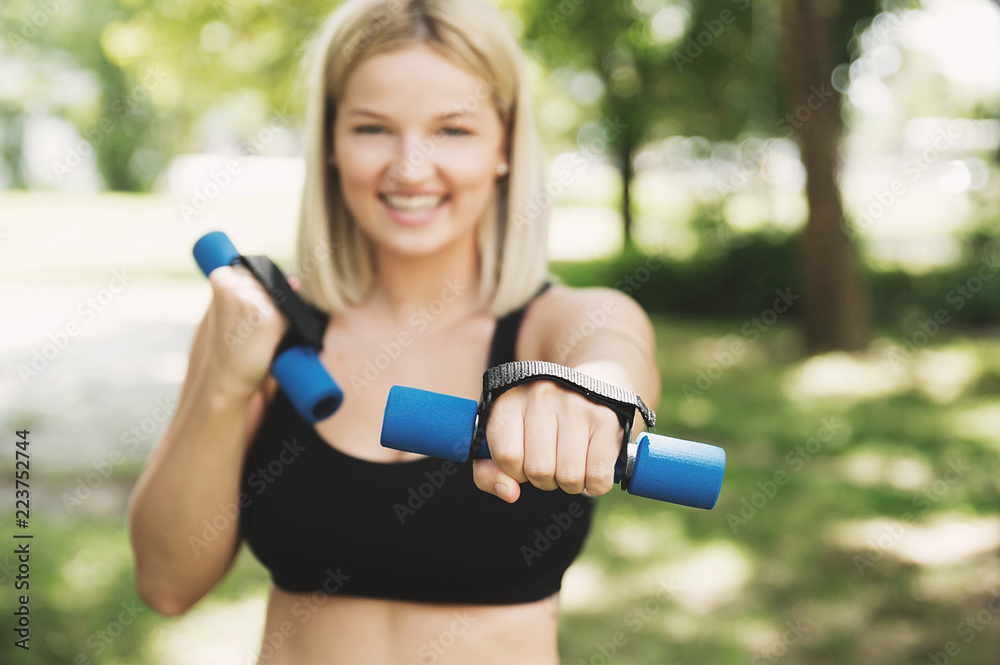 Young woman exercising with dumbbells Young woman exercising with dumbbells