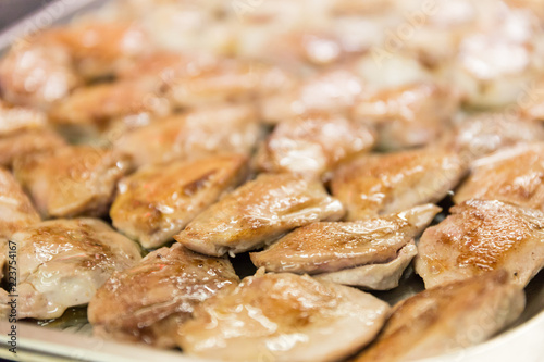 A plate of Chicken pieces cooked in a pan in a restaurant kitchen.