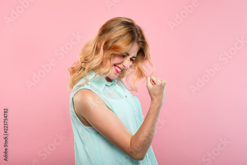 yes success and achievement. happy joyful smiling girl making a win gesture. excited thrilled woman portrait on pink background. photo