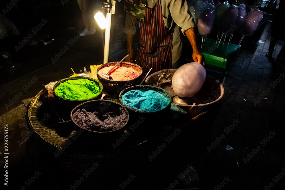 A cotton candy vendor using old wooden bowl and colourful sugar in Nong Khai at the Naga Fireball Festival