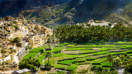 The beautiful mountain village of Balad Sayt sits in front of green fields in Wadi Bani Awf, Oman