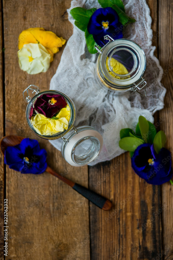 Φωτογραφία HLS dessert: granola, yogurt, fresh berries and edible flowers in a glass jar, on a natural wood background in rustic style