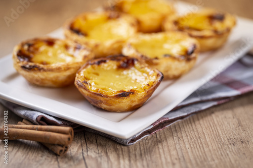 Typical Portuguese custard pies - "Pastel de Nata" or "Pastel de Belem". traditional portuguese pastry. On a wooden table.
