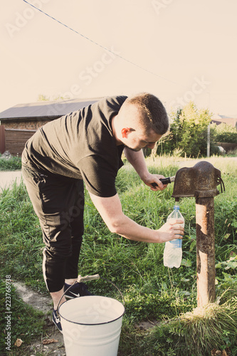 Мужчина набирает воду