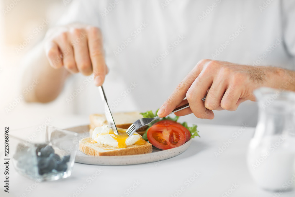 food, eating and people concept - close up of man having toasts with poached egg and vegetables for breakfast food, eating and people concept - close up of man having toasts with poached egg and vegetables for breakfast