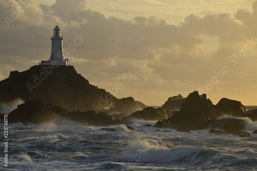 La Corbiere lighthouse, Jersey, U.K. A storm from the Atlantic lands at of coastal landmark in Autumn.