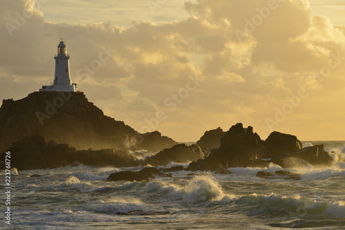 La Corbiere lighthouse, Jersey, U.K. A storm from the Atlantic reaches a coastal structure in Autumn.