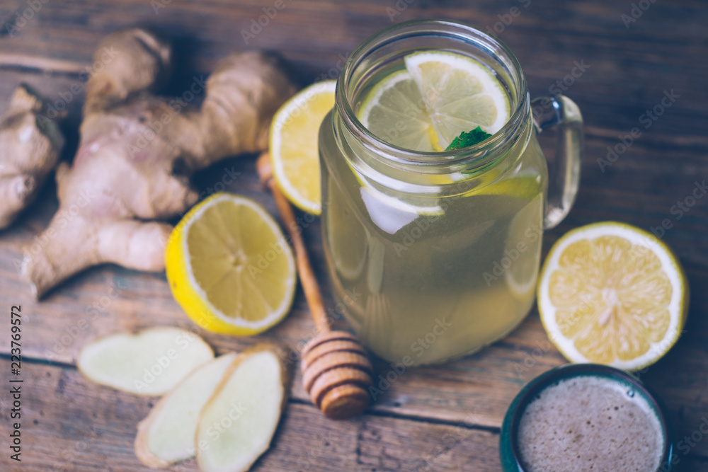 Hot drink with honey, lemon and ginger on wooden background. Concept of natural medicine. Winter or autumn drinks. Hot drink with honey, lemon and ginger on wooden background. Concept of natural medicine. Winter or autumn drinks.