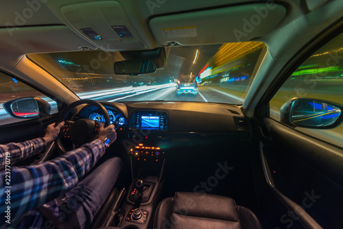 Fototapeta Naklejka Na Ścianę i Meble -  Movement of the car at night at a speed view from the interior, Brilliant road with lights with a car at high speed