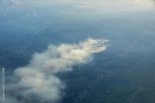 Aerial view of smoldering moor fire ignited by training activites on an army shooting range causing large smoke plumes