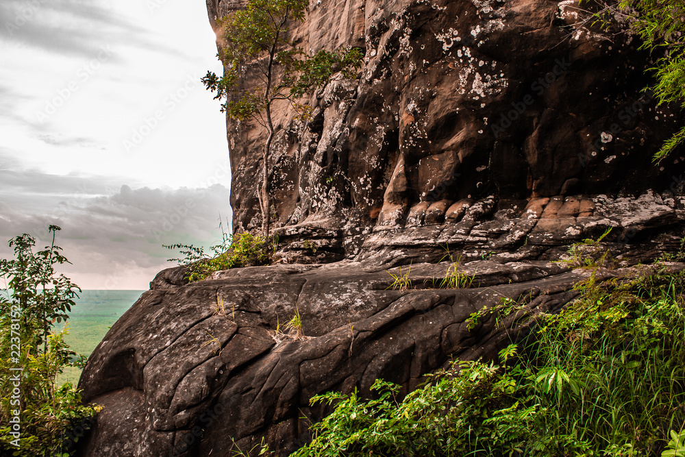 A cave cut into a red jagged mountainside high up on Phu Sing, Bueng Kan Thailand
