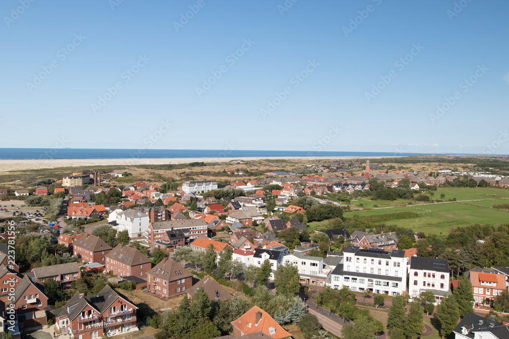 Obraz premium blick au f die bebauung und die natur mit blick auf die nordsee am horizont fotografiert während einer besichtigungstour vom leuchtturm auf der norsee insel borkum mit weit winkel objektiv