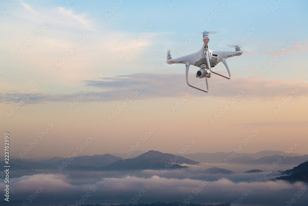 UAV drone copter flying with digital camera.Drone with high resolution digital camera. Flying camera take a photo and video.The drone with professional camera takes pictures of the misty mountains.