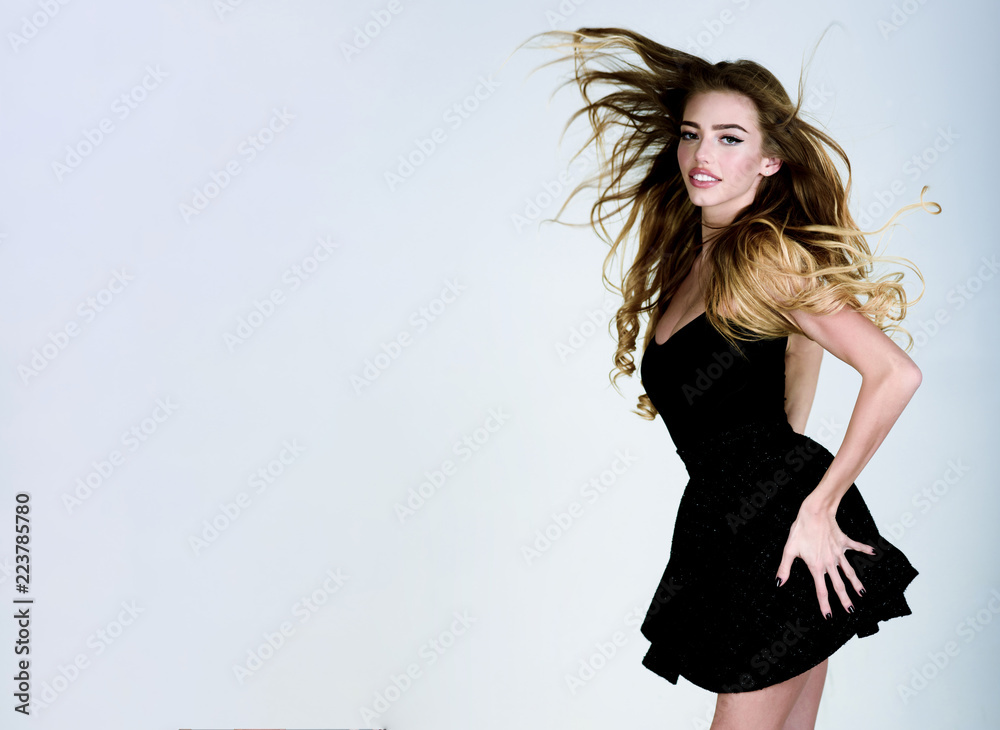 Beauty model girl with long flying hair&perfect makeup in black dress.  Beauty, fashion, make-up, hairstyle. Sensual seductive woman in stylish  little black dress. Elegant black mini dress. Copy space. Stock-Foto | Adobe