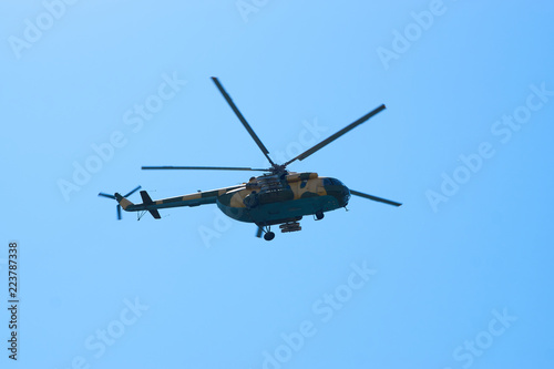 Fototapeta Naklejka Na Ścianę i Meble -  Military helicopters maneuvers in the blue sky. Group combat helicopters in flight during a military demonstration