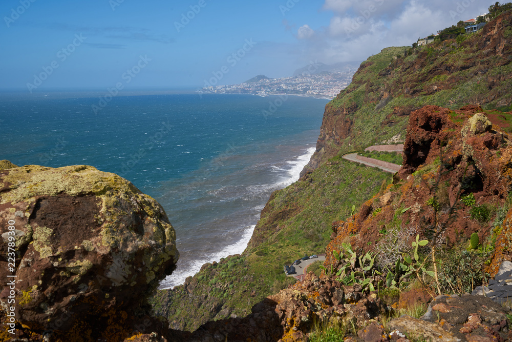 View of the coastline of Caniço, Madeira with Funchal city on the background