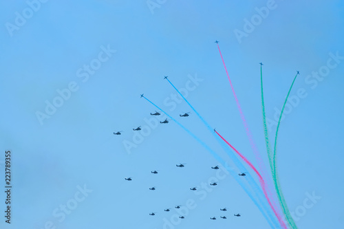 Military helicopters maneuvers in the blue sky. Group combat helicopters in flight during a military demonstration