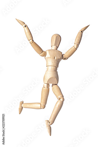 A wooden mannequin is happy jumping up and raising it s hands up  isolated on white background