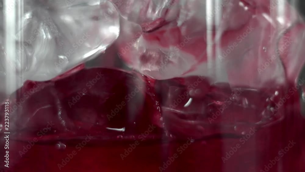 Macro shoot of Red martini pouring in a glass full with a ice cubes. Martini fill a glass with ice. Making of cocktails. Negroni. Macro shoot of Red martini pouring in a glass full with a ice cubes. Martini fill a glass with ice. Making of cocktails. Negroni.