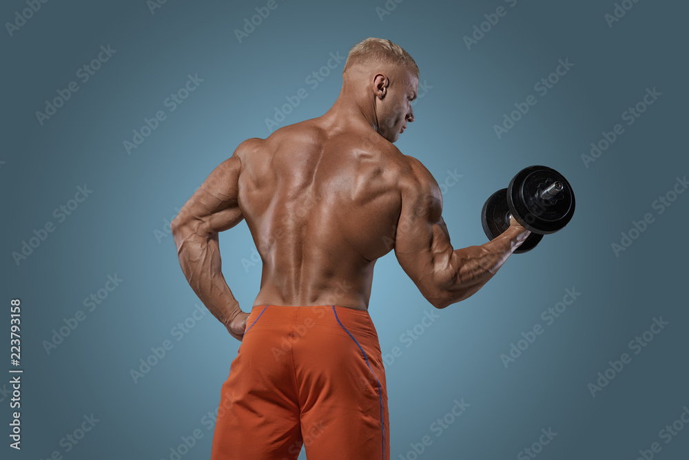Muscular bodybuilder guy doing exercises with dumbbel Muscular bodybuilder guy doing exercises with dumbbel