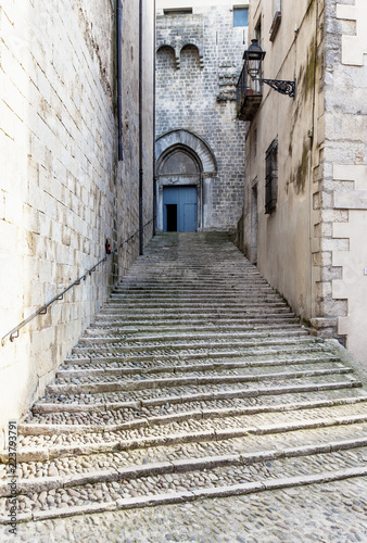 Fototapeta Naklejka Na Ścianę i Meble -  Steep stairs and narrow street in old town of Gerona, Spain