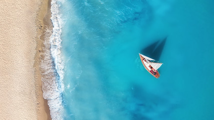 Yacht on the water surface from top view. Turquoise water background from top view. Summer seascape from air. Travel concept and idea