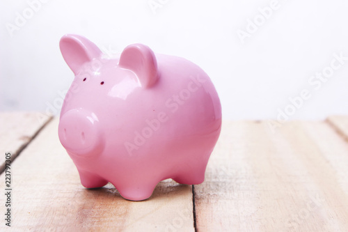 Pink piggy bank on wooden desk