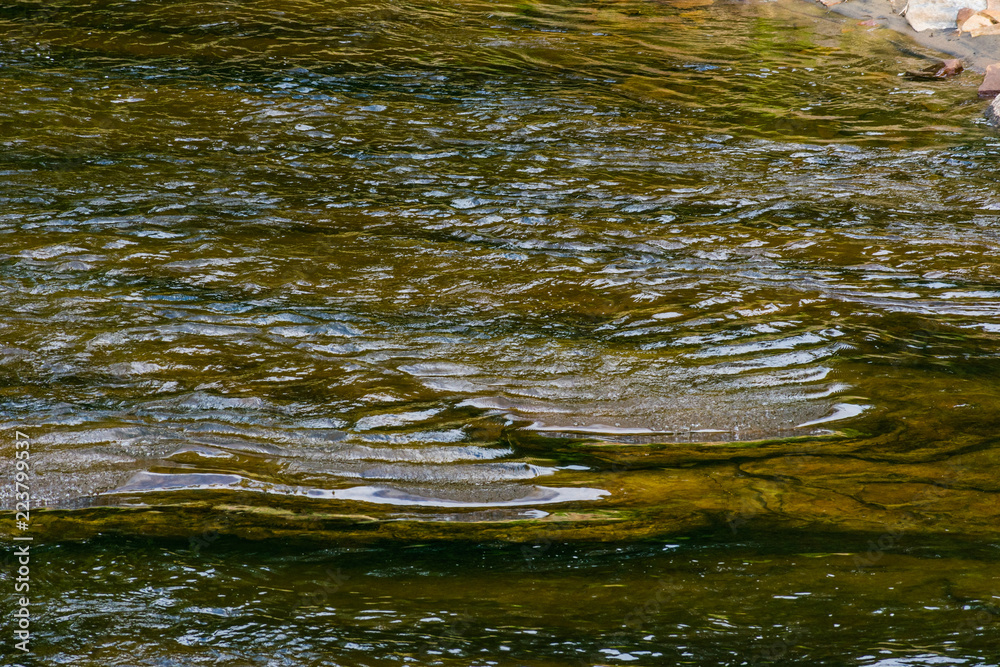 Ripples in the water as they flow over the rocks Ripples in the water as they flow over the rocks