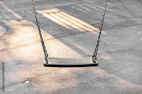 A single children's swings on chains in the Sun photo