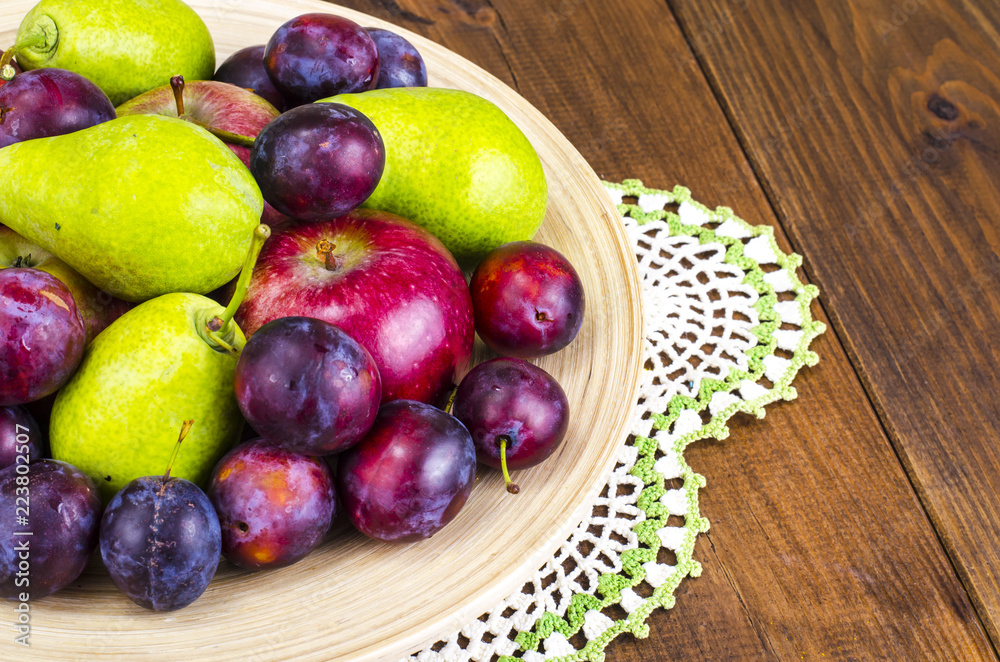 Ripe fruit on wooden plate
