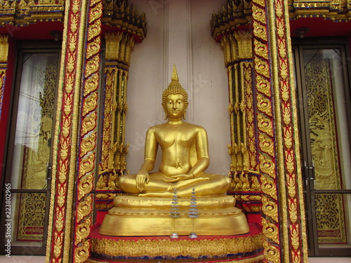 Golden seated Buddha on pedestal in Thailand.