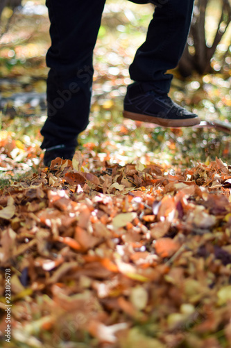 Child's feet Jumping in leaves in autumn 