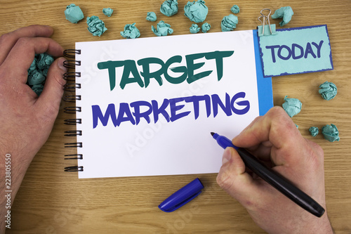 Writing note showing Target Marketing. Business photo showcasing Market Segmentation Audience Targeting Customer Selection Text two words blue white notepad blue marker hand crumbled blue paper