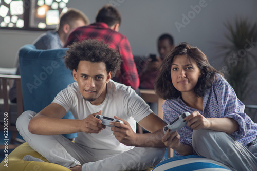 Happy couple playing video games at the modern startup office