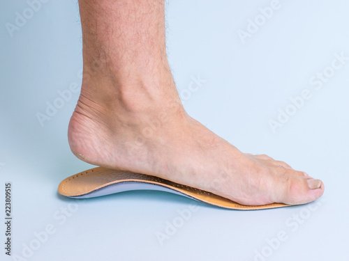 The man tries on the left foot orthopedic insole. Means for the treatment of flat feet.