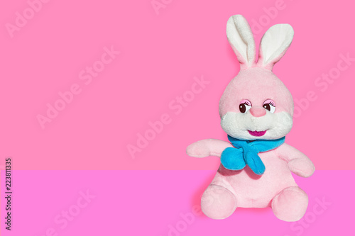 Soft toy pink Bunny with blue scarf isolated on colored background 