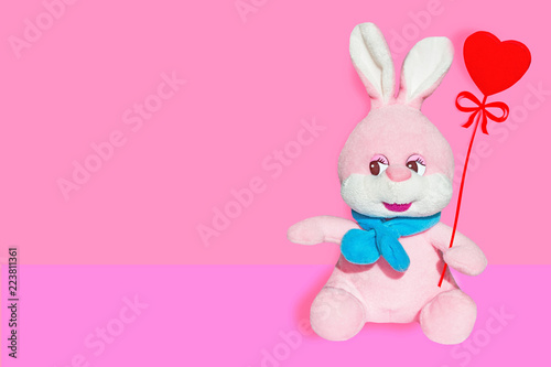 Soft toy pink Bunny with blue scarf isolated with heart 