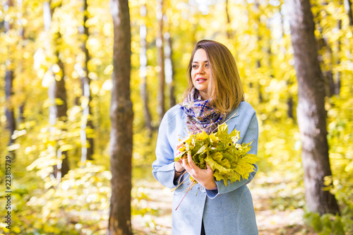 Fall  season  people concept - woman with yellow autumn leaves