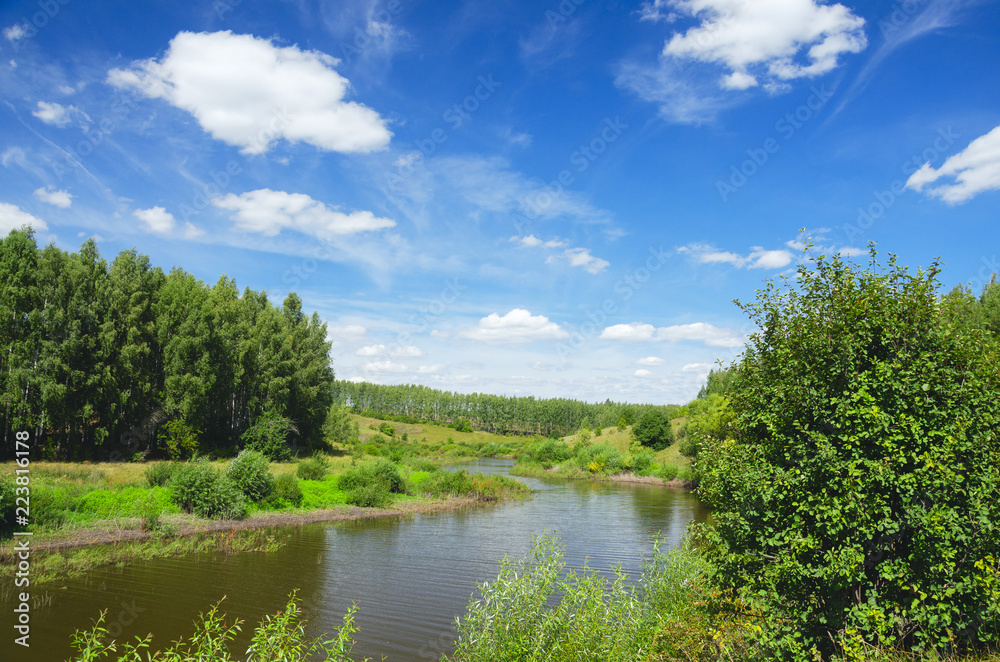 Sunny summer landscape with green hills,river curve and beautiful woods on a nice day.
