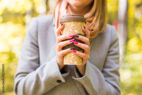 Autumn  nature and people concept - Close up of woman in grey coat holding a cup of coffee