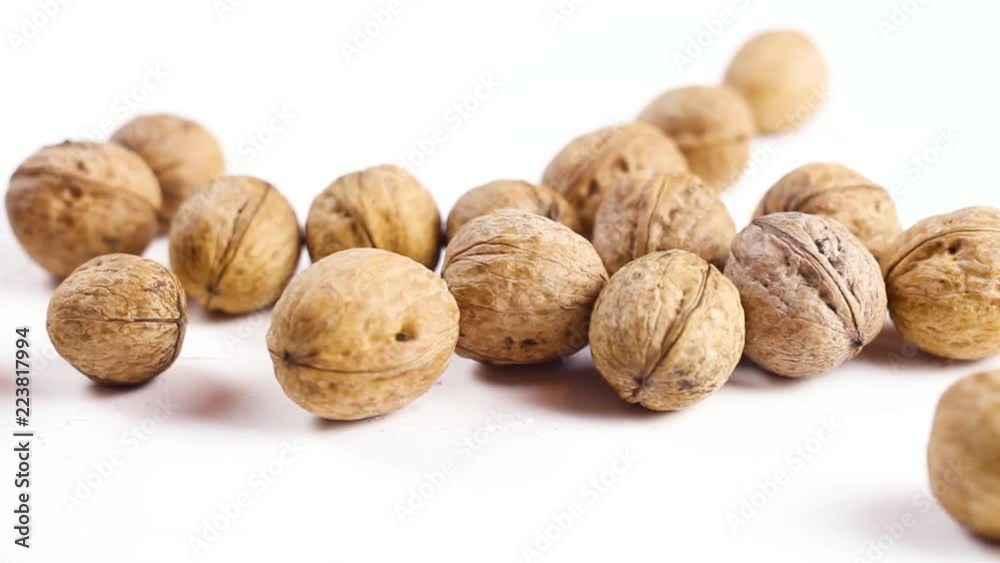 Fresh walnuts on white textured surface. Close up. Fresh walnuts on white textured surface. Close up.