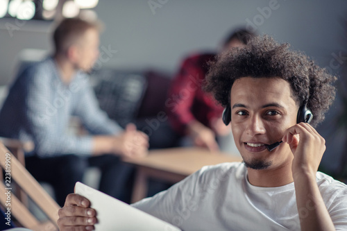 Laughing african american hipster software developer at computer at office of startup company