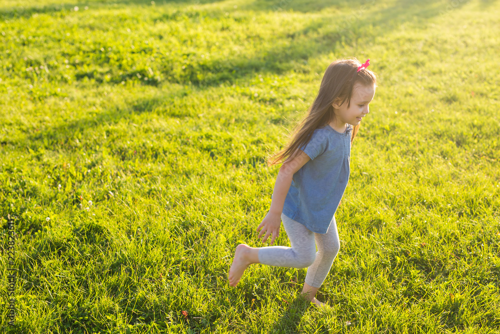 Fototapeta premium Little happy girl having fun in a summer park.
