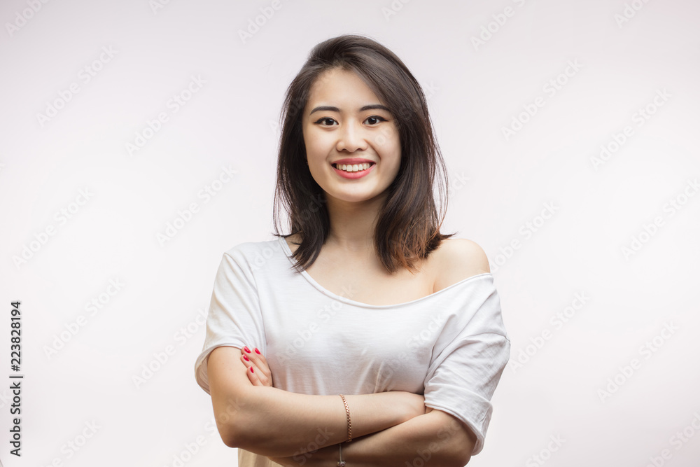 People, youth, beauty and lifestyle concept. Attractive young Asian female student wearing home clothing laughing happily at camera, having rest at home after lectures at college People, youth, beauty and lifestyle concept. Attractive young Asian female student wearing home clothing laughing happily at camera, having rest at home after lectures at college