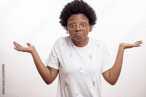 confused african awesome woman dressed casually shrugging shoulders and asking something.attitude concept