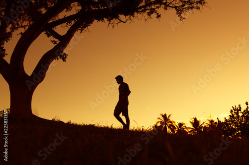 Silhouette of young man walking outdoors. 