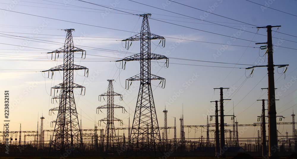 Industrial photo of high voltage towers with substation with sky background