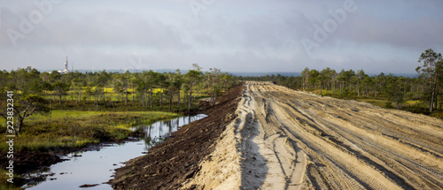 sand artificial road along the swamp to the drilling site