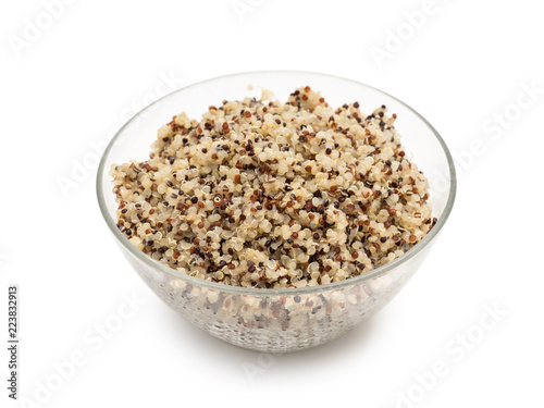 Cooked mixed quinoa seeds in a round glass bowl seen obliquely from above and isolated on white background